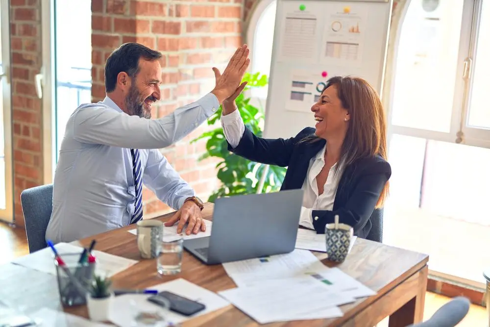 Un employé de doowup agence digitale et une cliente heureux